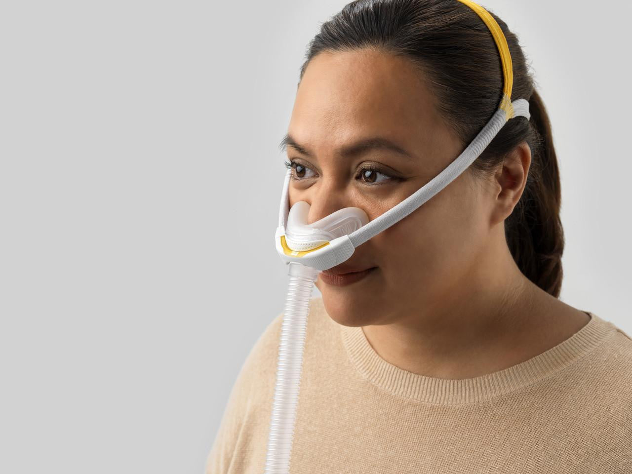 Fisher and Paykel Healthcare Fisher and Paykel Solo Nasal Interface - Individual Size Pack, woman wearing nasal interface for breathing aid with comfortable fit and adjustable straps.