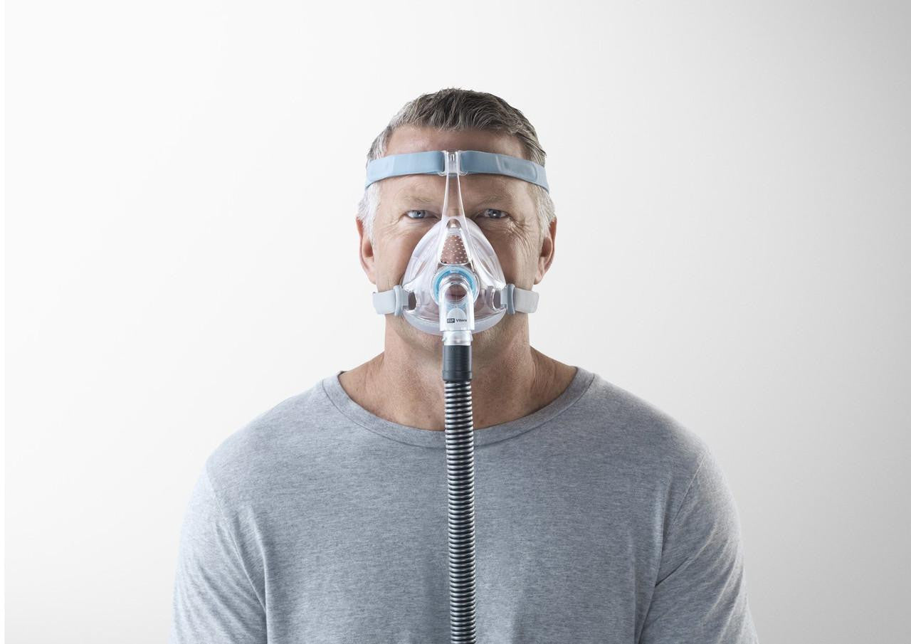 Fisher and Paykel Healthcare Fisher and Paykel Vitera CPAP Full Face Mask, a clear medical device worn on the face with adjustable straps and a connected breathing tube.