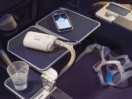 Resmed Airmini Ultimate Travel Pack + Battery, portable CPAP device with accessories on an airplane tray table.