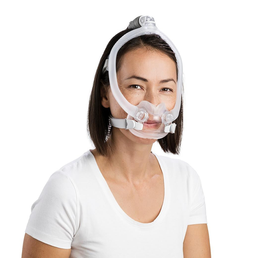 ResMed AirFit F30i CPAP mask, woman wearing the full-face CPAP mask with headgear and breathing tube on white background.