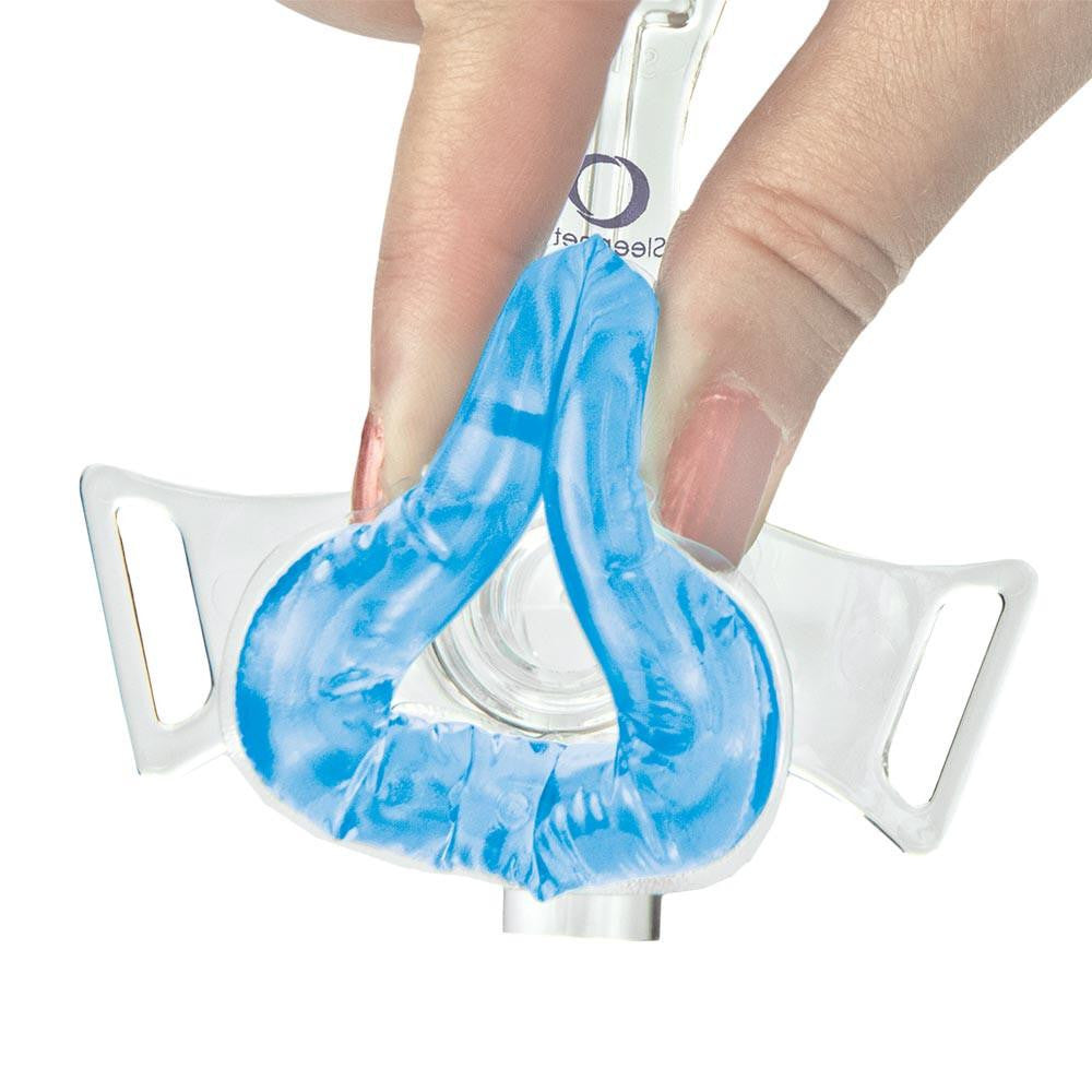 Sleepnet MiniMe 2 pediatric Nasal Mask, a small, clear nasal mask with a blue silicone cushion designed for children, held by a hand.